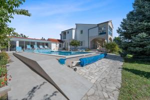 a swimming pool in front of a house at Villa Almas in Neorić