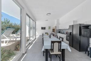 a kitchen with a long table and a large window at Villa Almas in Neorić