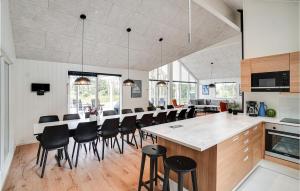 cocina y comedor con mesa grande y sillas en Pet Friendly Home In Nexø With Kitchen, en Neksø