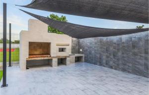 een patio met een open haard en een hangmat bij Lovely Home In Koritna With Wifi 