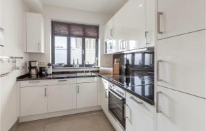 a white kitchen with white cabinets and a window at Master in Binz