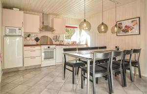 ホにあるStunning Home In Blvand With 4 Bedrooms, Sauna And Wifiのキッチン(テーブル、椅子、冷蔵庫付)