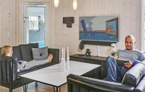 un uomo e una donna seduti sulle sedie in soggiorno di Lovely Home In Frederiksvrk With Indoor Swimming Pool a Melby