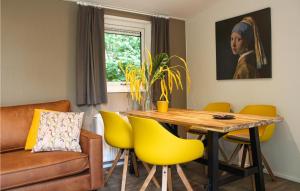 une salle à manger avec une table et des chaises jaunes dans l'établissement Chalet 34, à Oosterwolde