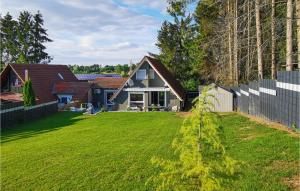 einen Hof mit einem Haus und einem Zaun in der Unterkunft Gorgeous Home In Ulrichstein With Kitchen in Ulrichstein