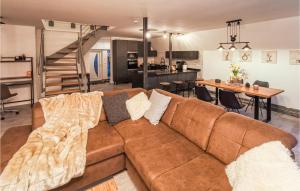 a living room with a brown couch and a kitchen at 2 Bedroom Beautiful Home In Ulrichstein in Ulrichstein
