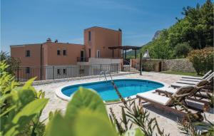 a villa with a swimming pool in front of a house at Cozy Home In Solin With House A Panoramic View in Solin