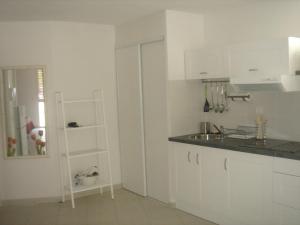 uma cozinha branca com um balcão e um lavatório em Appartement Balaruc-les-Bains, 2 pièces, 4 personnes - FR-1-680-13 em Balaruc-les-Bains