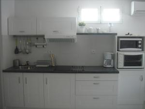 uma cozinha com armários brancos e electrodomésticos brancos em Appartement Balaruc-les-Bains, 2 pièces, 4 personnes - FR-1-680-13 em Balaruc-les-Bains