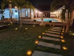 a yard with a statue and a swimming pool at night at Meyers Hua Hin in Hua Hin