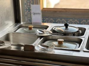 a kitchen with three pots and pans on a stove at Hotel Hayatt Sukkur in Kalar Goth