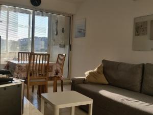 uma sala de estar com um sofá e uma mesa em Appartement Balaruc-les-Bains, 2 pièces, 2 personnes - FR-1-680-12 em Balaruc-les-Bains