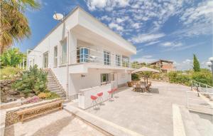 una casa bianca con patio arredato con tavolo e sedie di Amazing Home In Aragona -ag- With 4 Bedrooms, Wifi And Outdoor Swimming Pool ad Aragona
