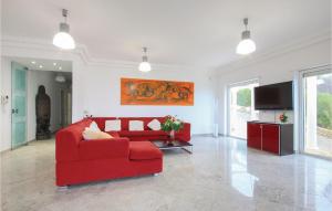 un soggiorno con divano rosso e TV a schermo piatto di Amazing Home In Aragona -ag- With 4 Bedrooms, Wifi And Outdoor Swimming Pool ad Aragona