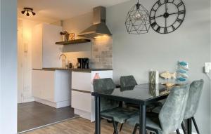 una cocina con mesa y sillas y un reloj en la pared en Amazing Apartment In Bruinisse With Wifi, en Bruinisse
