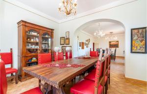 una sala da pranzo con tavolo in legno e sedie rosse di Gorgeous Home In Mogliano With Wifi a Mogliano