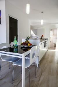 a kitchen with a table with a bowl of fruit on it at Nemira Sunny Apartments in Omiš