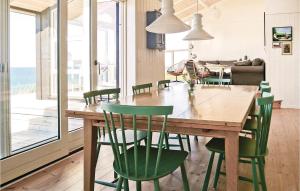 Rygård StrandにあるBeautiful Home In Allingbro With 3 Bedrooms, Sauna And Wifiのダイニングルーム(木製テーブル、緑の椅子付)