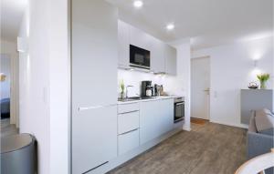 eine Küche mit weißen Schränken und ein Wohnzimmer in der Unterkunft Penthouse Comfort in Lembruch