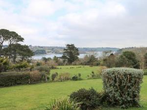 a field with a view of a body of water at Penarvon House in Helford