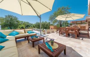 a patio with couches and tables and umbrellas at Stunning Home In Donji Zemunik With House A Panoramic View in Zemuniki