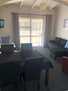 sala de estar con mesa y sofá en Rosetown Motel en Te Awamutu