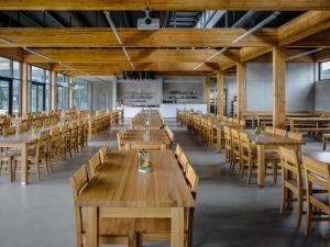a large dining room with wooden tables and chairs at Pivotel MMX in Dobřichovice