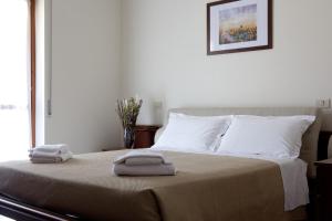 una camera da letto con un letto e due asciugamani di Residence Hotel Health House a Desenzano del Garda