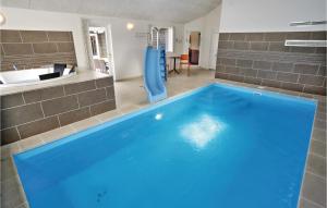 ブラーバンドにあるNice Home In Blvand With 8 Bedrooms, Wifi And Indoor Swimming Poolの屋内の滑り台付きの青い大型スイミングプール