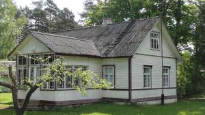 une petite maison blanche avec un toit noir dans l'établissement Hiirevända Holiday House, à Võsu