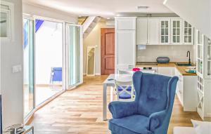 a kitchen with a blue chair and a table at 3 Bedroom Lovely Apartment In Lukecin in Łukęcin