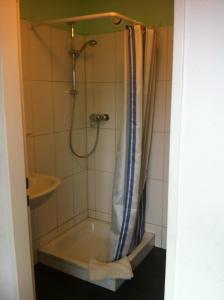 ducha con bañera y cortina de ducha en Hansehus en Hamburgo