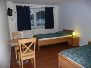 um quarto com duas camas e uma mesa e uma janela em Hansehus em Hamburgo
