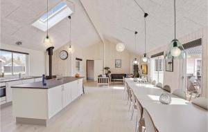 a kitchen and living room with white cabinets and tables at 8 Bedroom Stunning Home In Vejby in Vejby