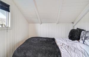 a bedroom with a bed in a white room at 2 Bedroom Stunning Home In Karrebksminde in Karrebæksminde