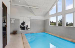 ブロックフスにあるStunning Home In Blokhus With Indoor Swimming Poolの窓付きの客室内の大きなスイミングプールを提供しています。
