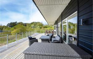 a patio with a table and chairs on a deck at Beautiful Home In Spttrup With Sauna in Spottrup