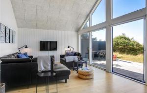 - un salon avec un canapé et une télévision dans l'établissement Stunning Home In Blokhus With Indoor Swimming Pool, à Blokhus