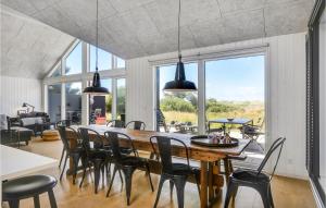 a dining room with a large wooden table and chairs at Stunning Home In Blokhus With Indoor Swimming Pool in Blokhus