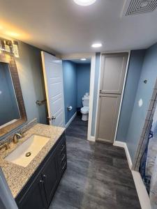 La salle de bains est pourvue d'un lavabo, de toilettes et de murs bleus. dans l'établissement Paradise on Lake Harris Apt #101, à Leesburg 24 autres photos