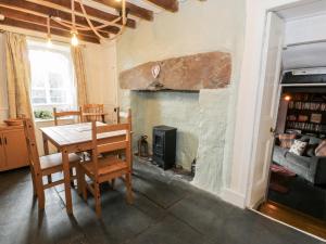 a dining room with a table and a fireplace at Mill Cottage in Blaenau-Ffestiniog