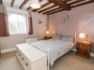 a bedroom with a white bed and a window at Mill Cottage in Blaenau-Ffestiniog