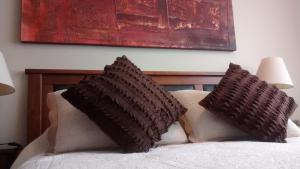 a bed with two brown pillows on top of it at Temporary Rent Viña del Mar in Viña del Mar