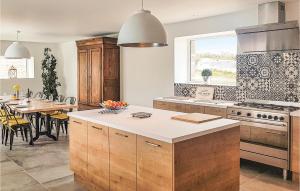 une cuisine avec des placards en bois et une salle à manger avec une table dans l'établissement Gorgeous Home In Guisseny With Kitchen, à Guissény