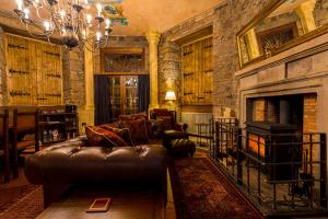 a living room with a leather couch and a fireplace at Craigiehall Temple in Edinburgh