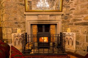 a stone fireplace with a fire in it at Craigiehall Temple in Edinburgh