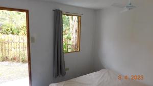 sypialnia z łóżkiem i oknem w obiekcie Cute Quiet Private Room w own Kitchen, CR, Porch w Panglao City