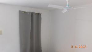 Habitación con ventilador de techo y cortina de ducha. en Cute Quiet Private Room w own Kitchen, CR, Porch, en Panglao