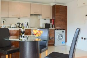 a kitchen with a table with a bowl of fruit on it at Southampton Serviced Apartments in Southampton +14 photos