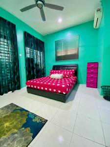 um quarto com uma cama vermelha e paredes verdes em DeSyafiq Homestay em Kuala Kedah